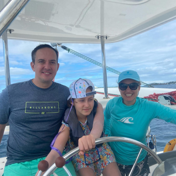 a group of people standing on a boat posing for the camera