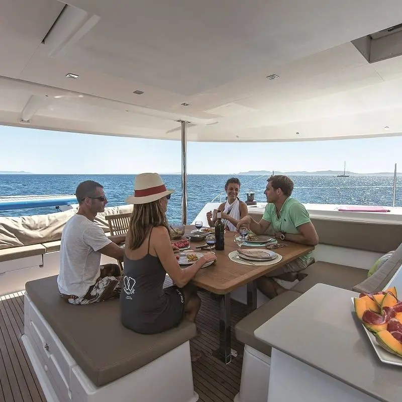 a group of people sitting at a table with food