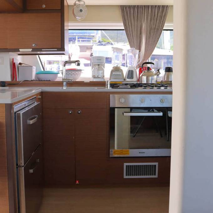 Modern kitchen with stove, appliances, and fire blanket in boat.