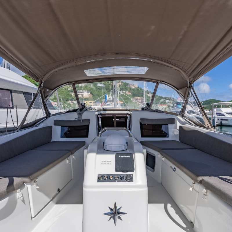 Interior of a sailboat cockpit with two steering wheels and navigation equipment.