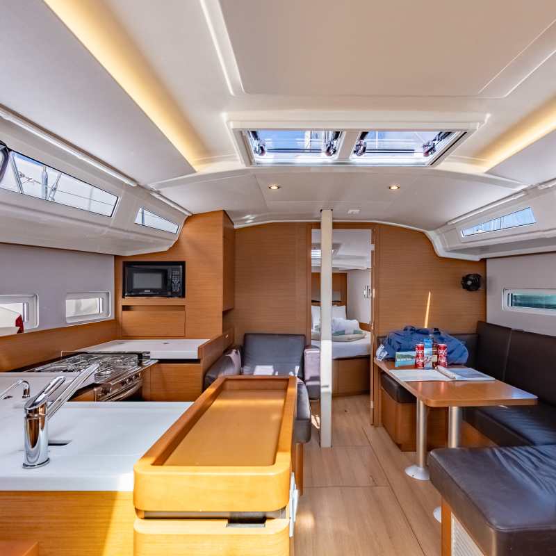 Interior of a modern sailboat with kitchen and seating area.